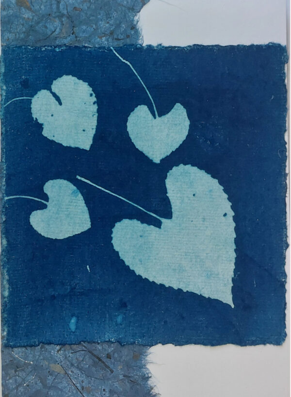 4 small heart shaped violet leaves on dark blue square, over vertical lighter blue mulberry paper, on white card