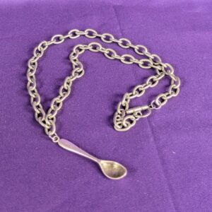 A necklace made of a heavy oxidized silver textured cable chain and an oxidized silver spoon pendant